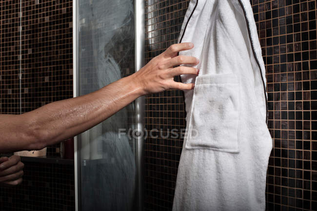 Man reaching for bathrobe in shower — Stock Photo