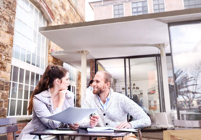 Uomo e donna d'affari discutono di scartoffie sul patio dell'ufficio — Foto stock