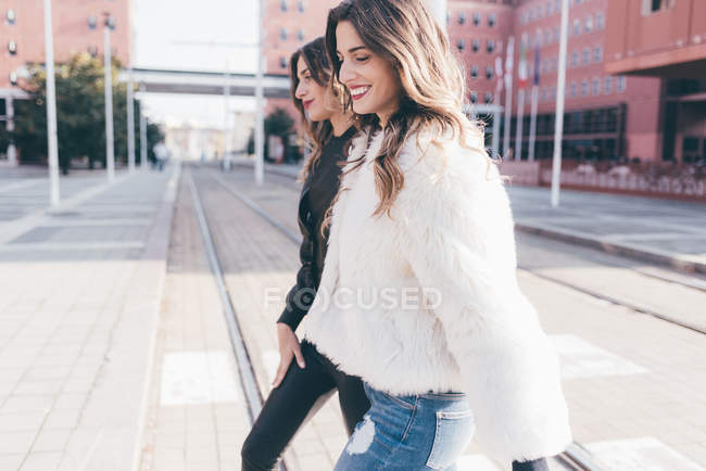 Twin sisters, crossing zebra outdoors and smiling — Stock Photo