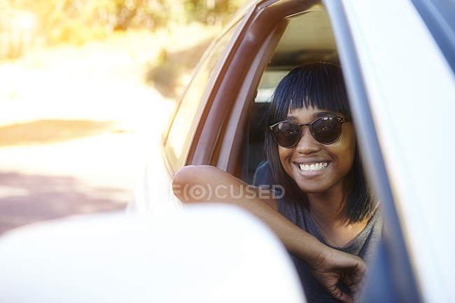 Porträt einer jungen Frau, die aus dem Autofenster blickt — Stockfoto