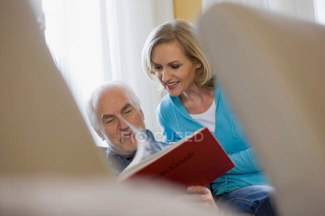 Old father and daughter reading book — Stock Photo