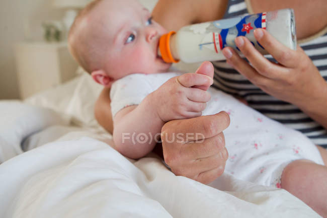 Bottiglia madre che alimenta bambino — Foto stock