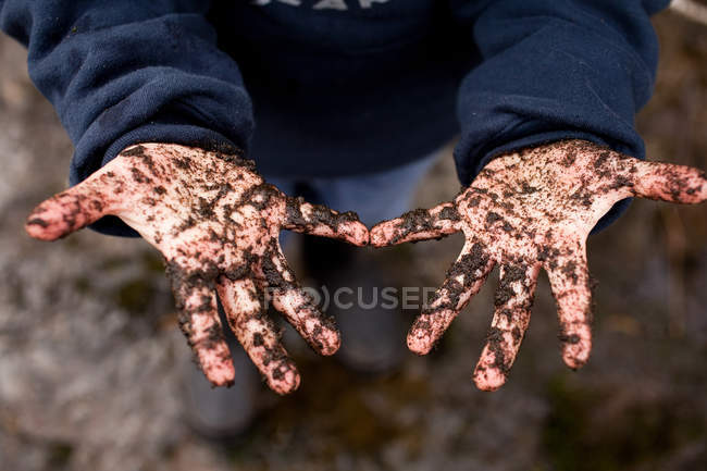 Junge mit erdbedeckten Händen — Stockfoto