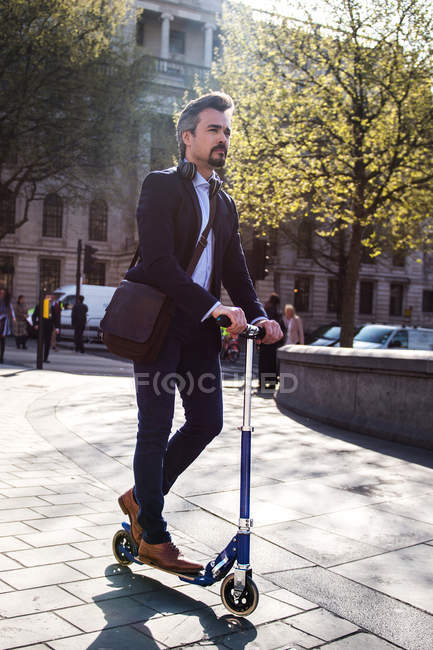 Businessman on scooter, Trafalgar Square, London, UK — Stock Photo