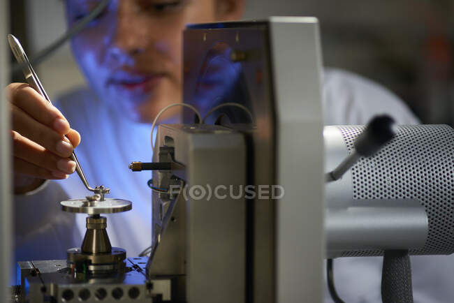 Ученые размещают объект на научном оборудовании с помощью пинцета — стоковое фото
