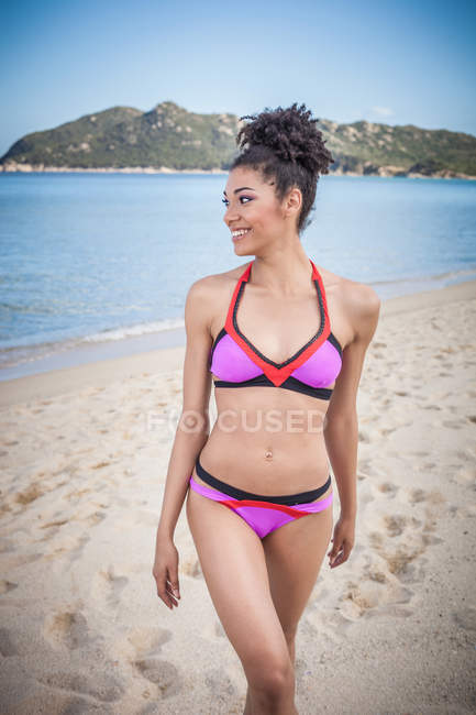 Bella giovane donna in bikini rosa in piedi sulla spiaggia, Costa Rei, Sardegna, Italia — Foto stock