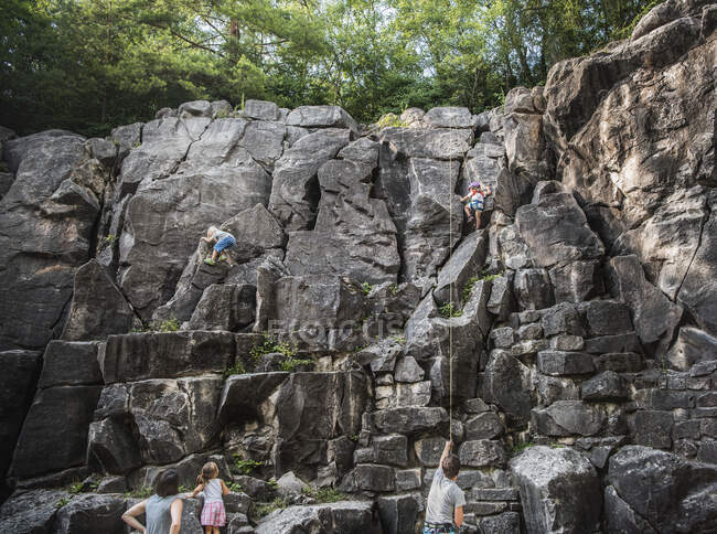 Familia escalada roca cara - foto de stock