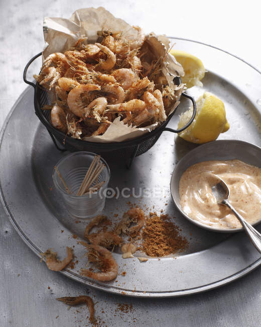 Crevettes grillées au paprika avec moitiés de citron pressé et sauce sur étain — Photo de stock
