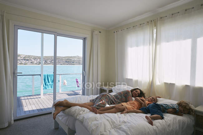 Mother and children sleeping on bed in houseboat, Kraalbaai, South Africa — Stock Photo