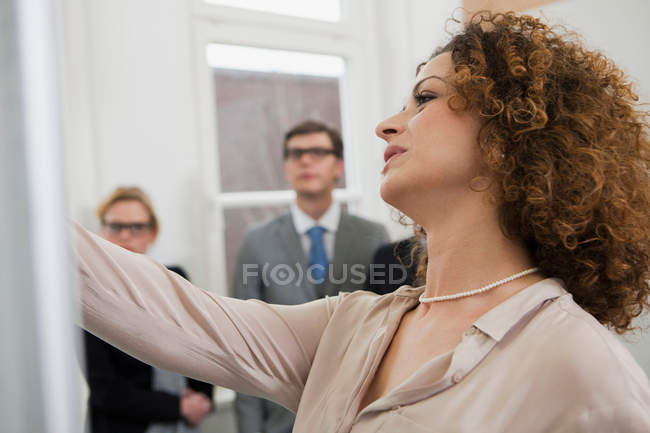 Businesswoman drawing on board — Stock Photo