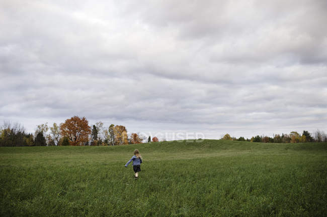 Young girl running in open field, Lakefield, Ontario, Canada — Stock Photo