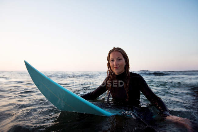 Жінка сидить на дошку для серфінгу у воді — стокове фото