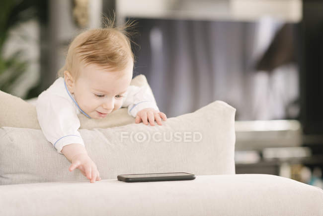 Baby looking interested in mobile phone — Stock Photo