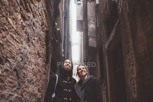 Couple looking up from alley, Venice, Italy — Stock Photo