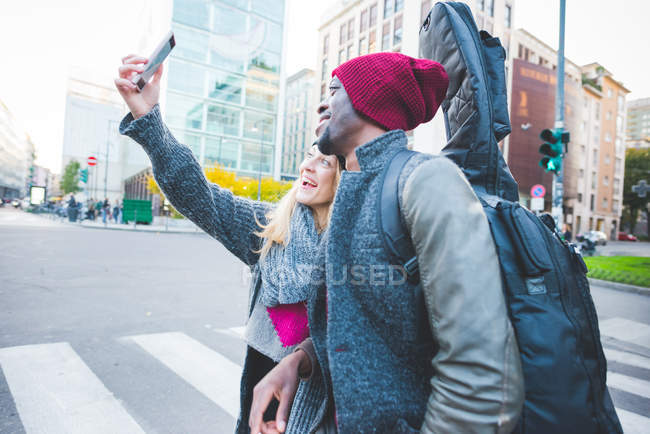 Casal tirando selfie com smartphone na rua — Fotografia de Stock