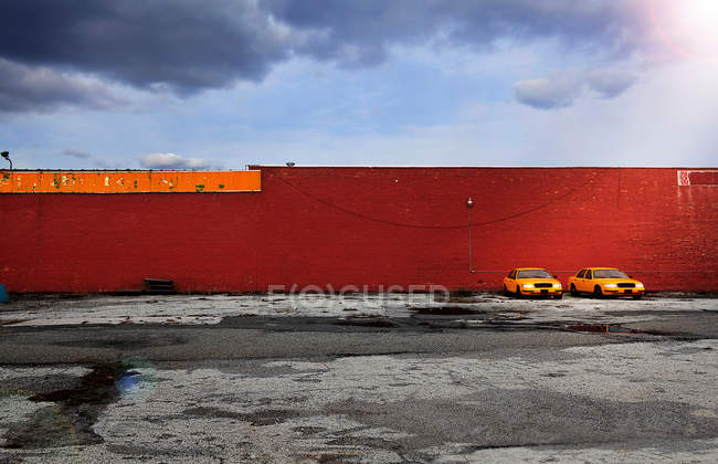 Taxi cabs against red wall — Stock Photo
