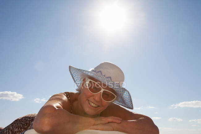Donna anziana prendere il sole sulla spiaggia — Foto stock
