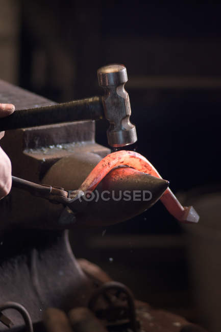 Farrier forching horseshoe on anvil, cropped image — стоковое фото