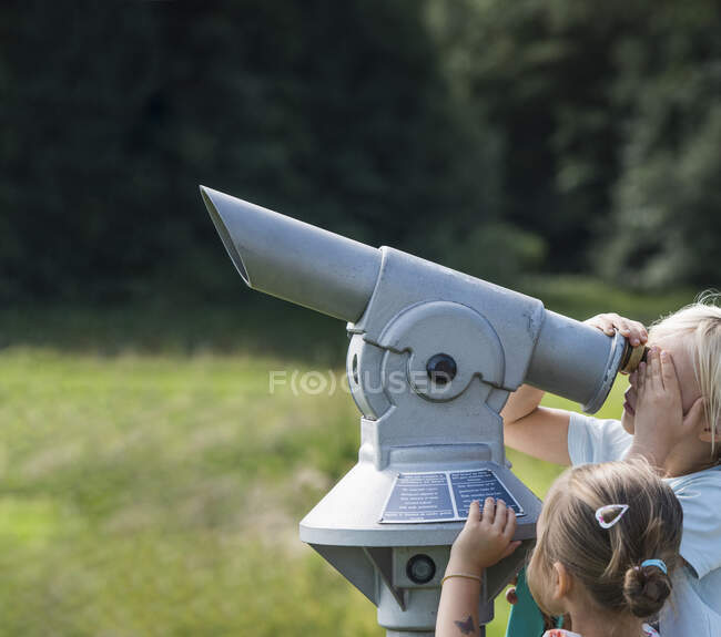 Brother and sister looking through binoculars — Stock Photo