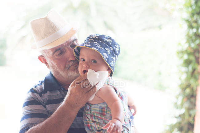 Nonno pulire il mento del bambino con fazzoletto — Foto stock