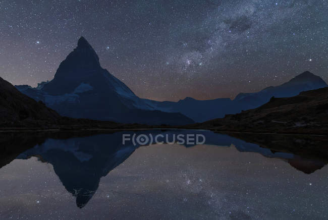 Matterhorn sob céu estrelado refletindo na água, Zermatt, Suíça — Fotografia de Stock