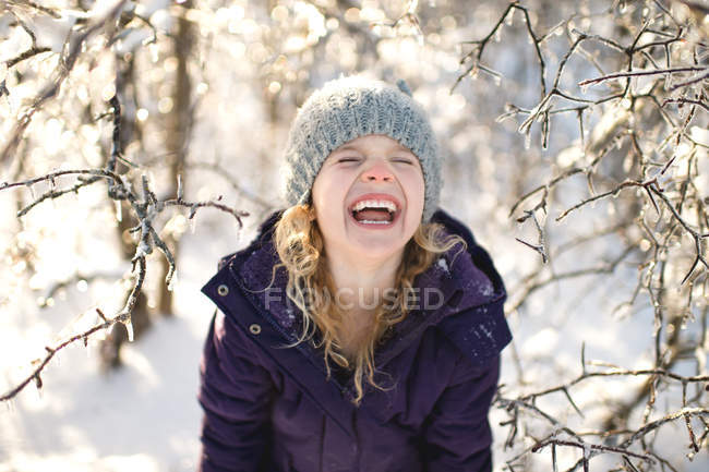 Portrait of young girl laughing, in snowy landscape — Stock Photo