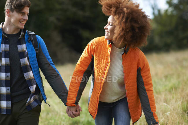 Couple holding hands in field — Stock Photo