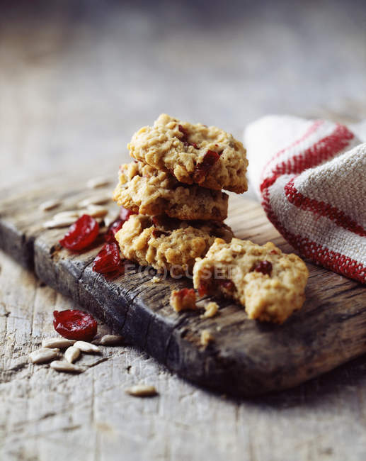 Oat and cranberry cookies on rustic wooden board — Stock Photo