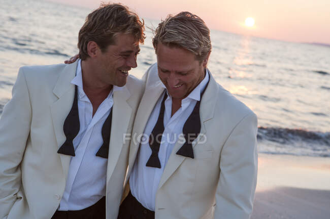 Feliz casal de homens recém-casados na praia ao pôr do sol, Maiorca, Espanha — Fotografia de Stock