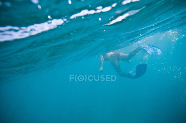 Женщина в плавниках плавает в океане — стоковое фото
