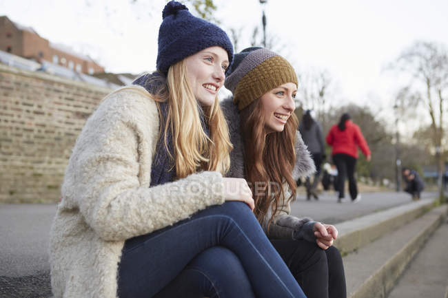 Due amiche sedute su gradini all'aperto — Foto stock