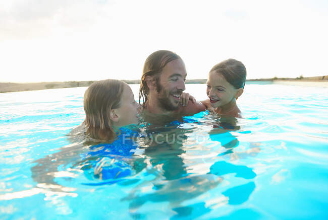 Мужчина в бассейне с дочерью и сыном, Буонконвенто, Тоскана, Италия — стоковое фото
