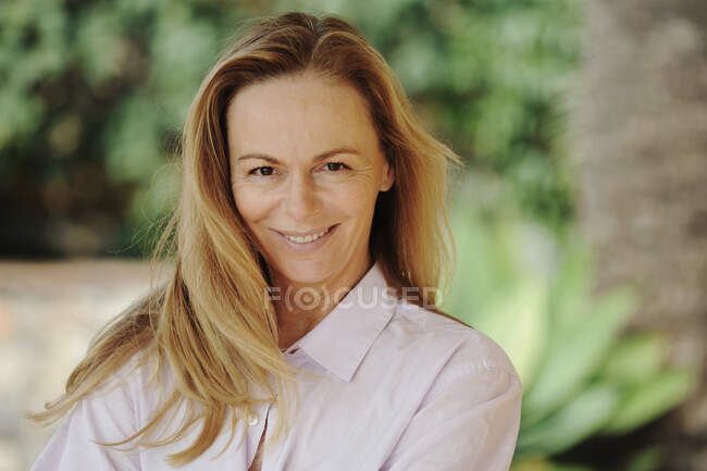 Mujer sonriendo en el patio trasero - foto de stock