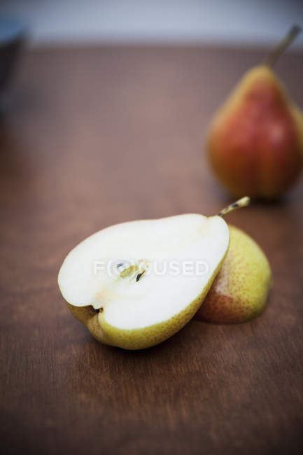Halved pear on wooden table — Stock Photo