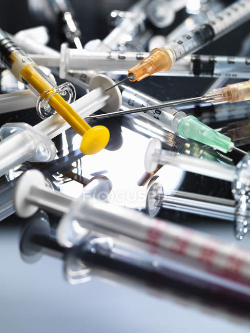 Variedade de seringas hipodérmicas colocadas na superfície de vidro — Fotografia de Stock
