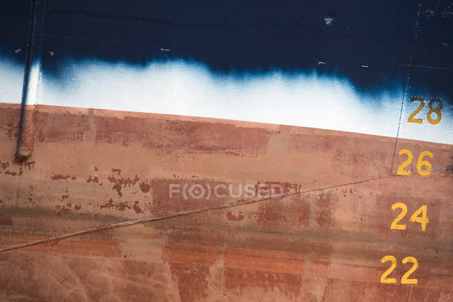 Detail of red, white and blue unfinished ship hull in ship painters yard — Stock Photo