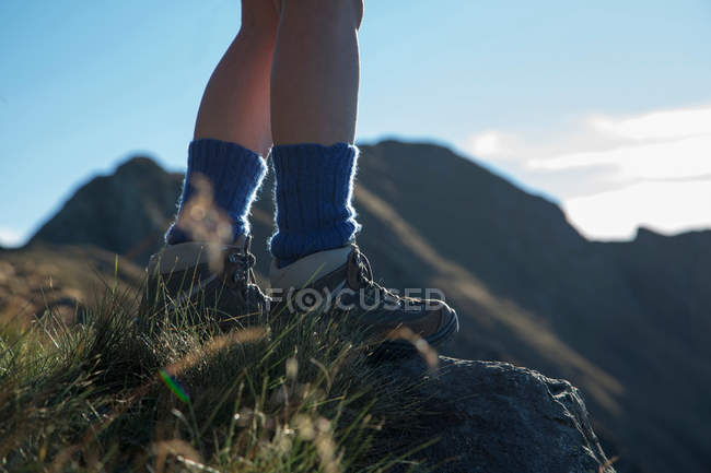 Jambes de femme randonnée sur colline rurale — Photo de stock