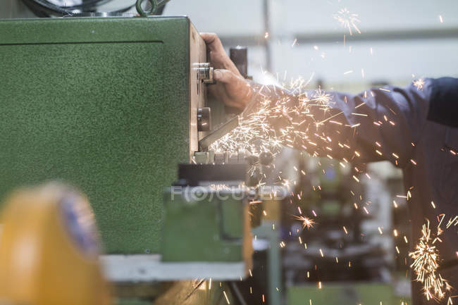 Man monitoring grinding machine in workshop — Stock Photo