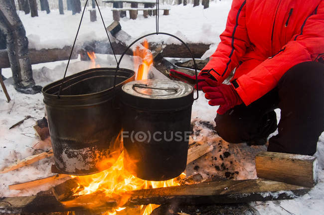 Cropped view of woman warming hands on campfire, Russia — Stock Photo
