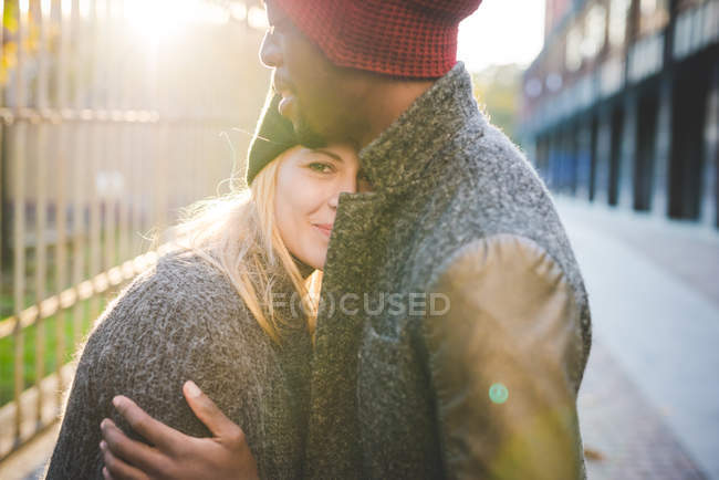 Couple hugging beside steel fence — Stock Photo