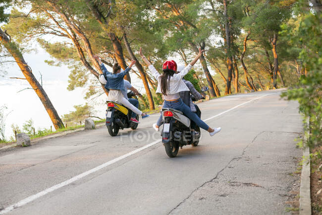 Vista trasera de dos parejas montando ciclomotores en carretera rural, Split, Dalmacia, Croacia - foto de stock
