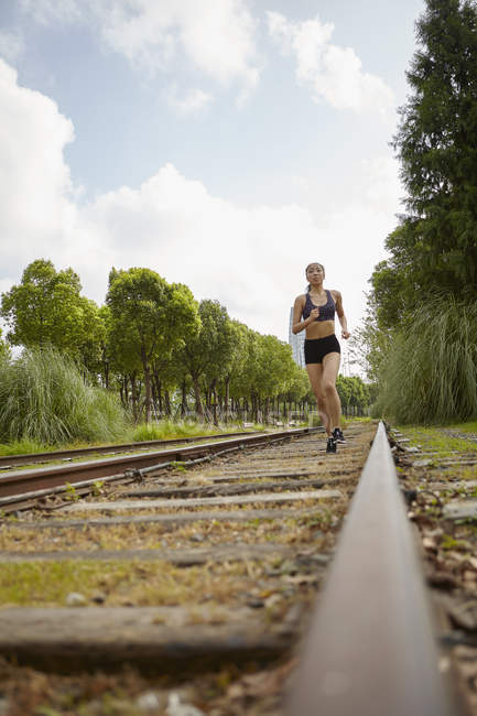Woman jogging on railway track — Stock Photo