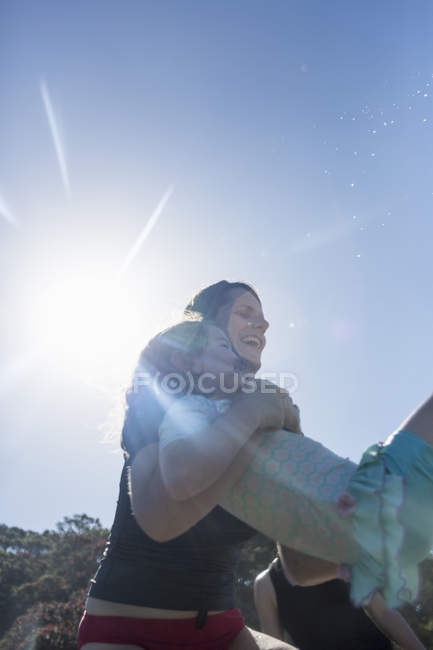 Mutter hebt Mädchen über Ozeanwellen, Heißwasserstrand, Inselbucht, Neuseeland — Stockfoto