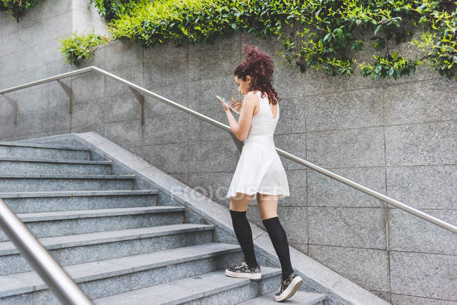 Frau steigt mit digitalem Tablet Stufen hinauf — Stockfoto