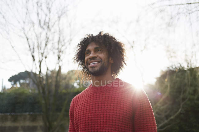 Homem vestindo camisola de lã vermelha olhando para longe sorrindo — Fotografia de Stock