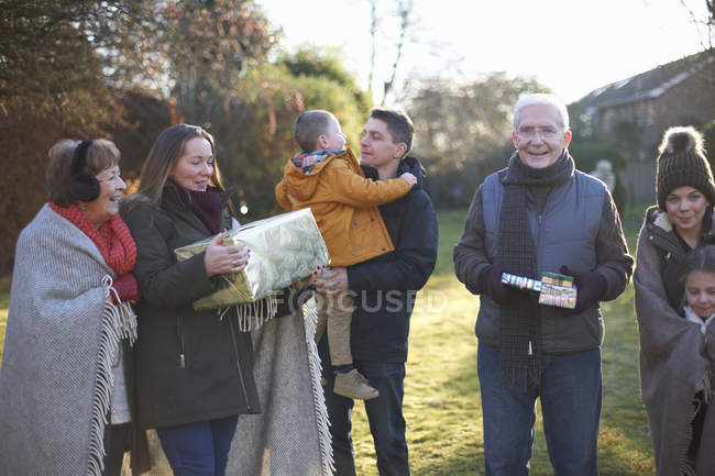 Family at birthday celebration in garden together during cold weather — Stock Photo