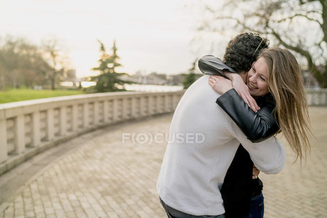 Pareja romántica abrazándose en Battersea Park, Londres, Reino Unido - foto de stock