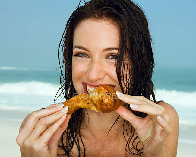 Young women eating a chicken leg — Stock Photo
