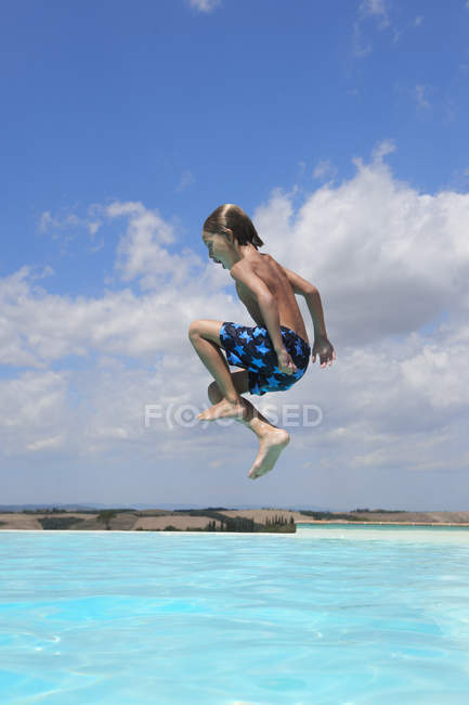 Boy jumping into swimming pool, Buonconvento, Toscana, Itália — Fotografia de Stock