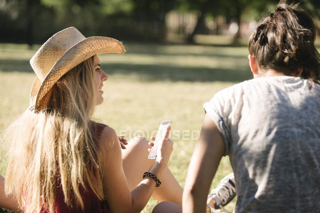 Rear view of female friends chatting in park — Stock Photo